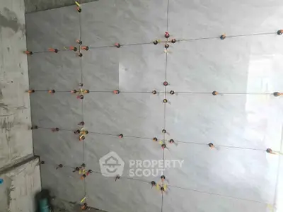 Under-construction wall with tiles being installed in a modern property.