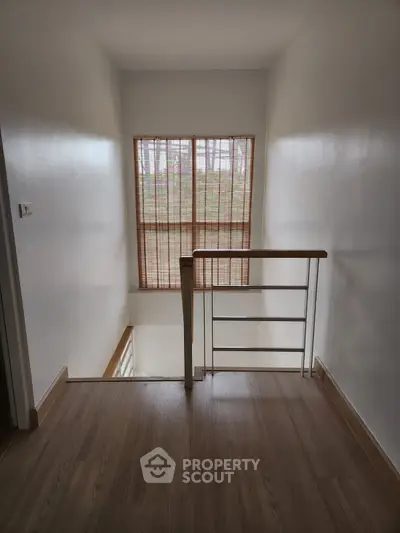 Bright stairway with wooden flooring and large window view
