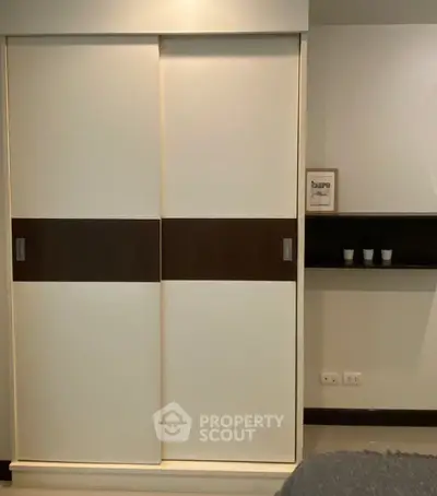 Modern bedroom with sleek sliding closet doors and minimalist decor.