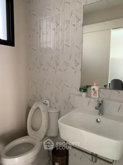 Modern bathroom with stylish tiles and compact sink design