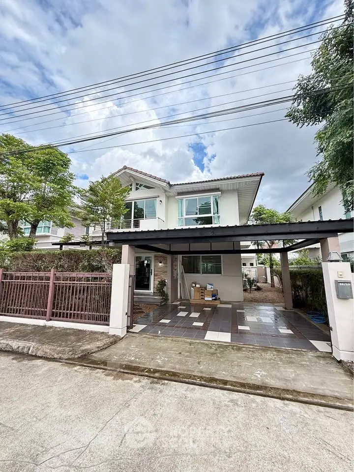 Charming two-story house with spacious driveway and lush greenery, perfect for family living.