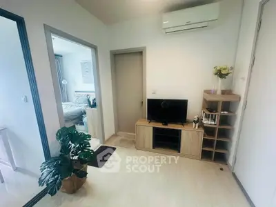 Modern apartment interior with TV, air conditioning, and bedroom view.