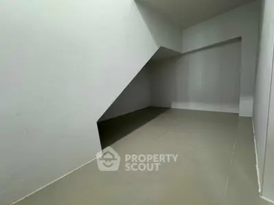 Spacious under-stair storage area with sleek tiled flooring