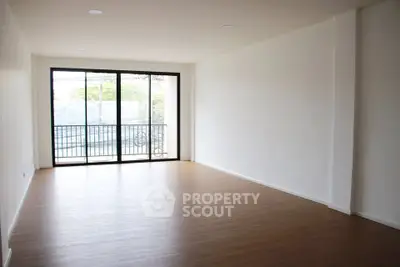 Spacious empty living room with large windows and wooden flooring