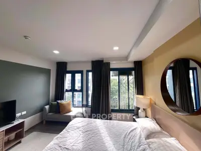 Modern bedroom with large windows and stylish decor in a contemporary apartment.