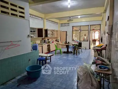 Spacious room with blue tile flooring and open kitchen layout, ideal for creative renovation.