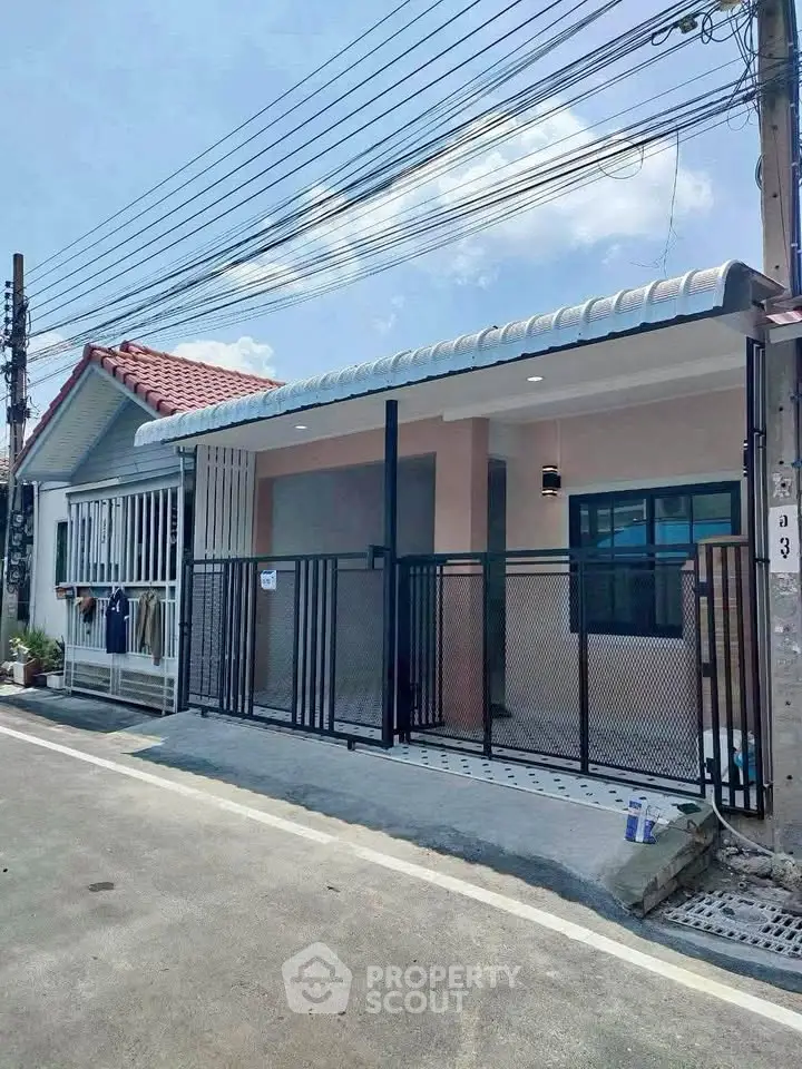 Charming single-story home with modern facade and gated entrance in a quiet neighborhood.