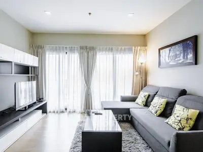Modern living room with sleek furniture and large windows for natural light.