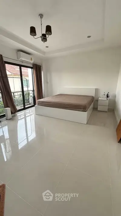 Spacious bedroom with large windows and modern furnishings for a bright and airy feel.