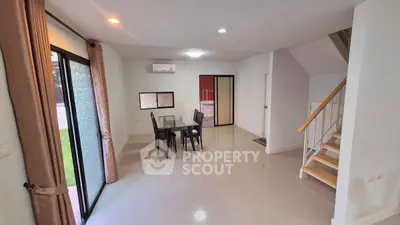 Spacious modern dining area with sleek staircase and garden view, perfect for family gatherings.