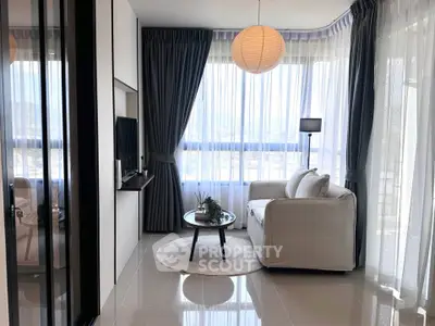 Modern living room with large windows and stylish decor, offering a bright and inviting atmosphere.