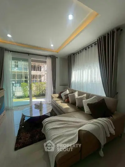 Modern living room with cozy sectional sofa and large windows for natural light.