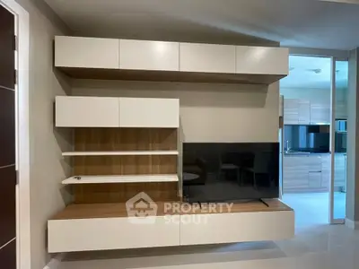 Modern living room with sleek TV unit and open kitchen view