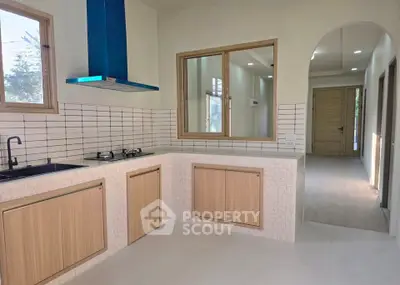 Modern kitchen with sleek design, featuring gas stove and ample natural light, perfect for culinary enthusiasts.