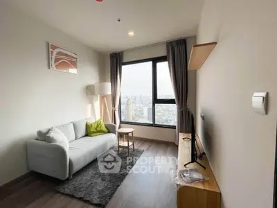 Modern living room with city view, featuring cozy sofa and sleek TV setup.