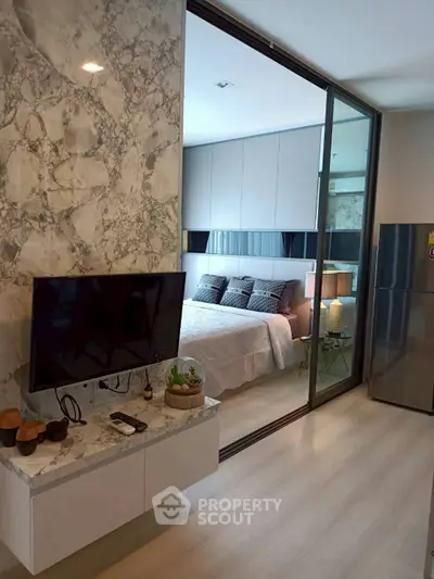 Modern bedroom with marble accent wall and sleek TV setup