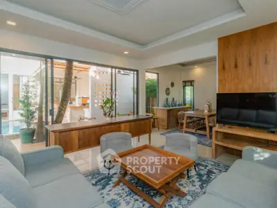 Spacious living room with modern furniture and pool view, perfect for relaxation and entertainment.