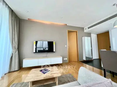 Modern living room with sleek TV setup and stylish furniture in a bright apartment.