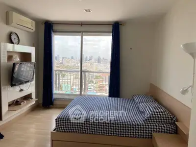 Modern bedroom with city view, featuring a cozy bed, wall-mounted TV, and large window with curtains.