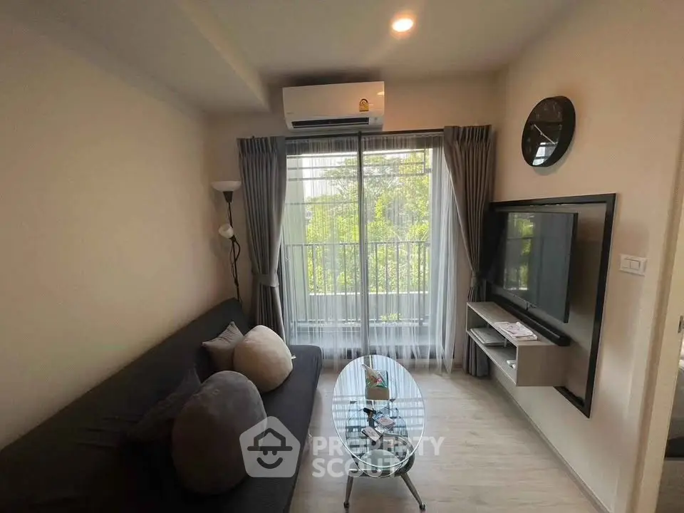 Cozy living room with modern decor, large window, and wall-mounted TV in a stylish apartment.