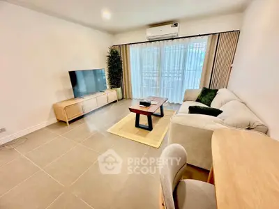 Spacious modern living room with large TV and comfortable seating, perfect for relaxation.