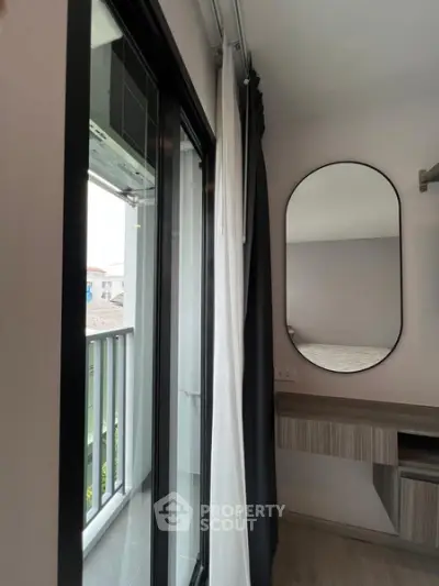 Modern bedroom with balcony access and stylish mirror