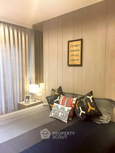Stylish bedroom with modern decor and cozy ambiance, featuring elegant pillows and wall art.