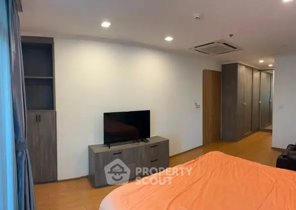 Spacious bedroom with modern furniture and built-in wardrobe