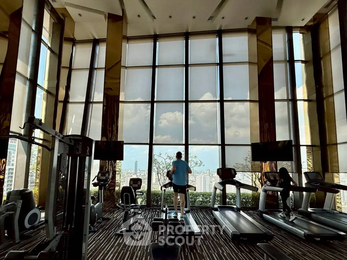 Luxurious high-rise gym with panoramic city views and modern fitness equipment.
