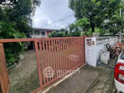 Charming suburban home with lush garden and secure gated entrance, perfect for family living.