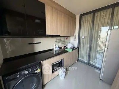 Modern kitchen with sleek cabinetry, built-in appliances, and balcony access.