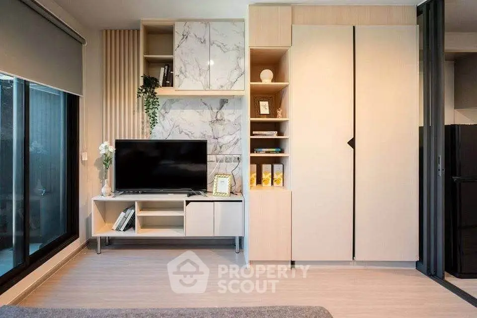 Modern living room with stylish built-in storage and large window for natural light.