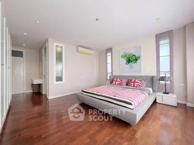 Spacious modern bedroom with stylish decor and hardwood floors