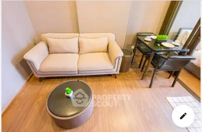 Modern living room with cozy sofa and stylish dining area in a compact apartment.