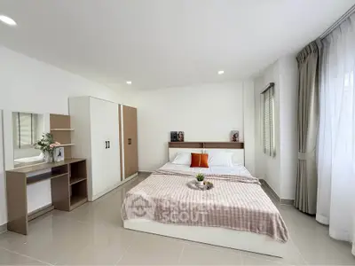 Spacious modern bedroom with elegant decor and natural light