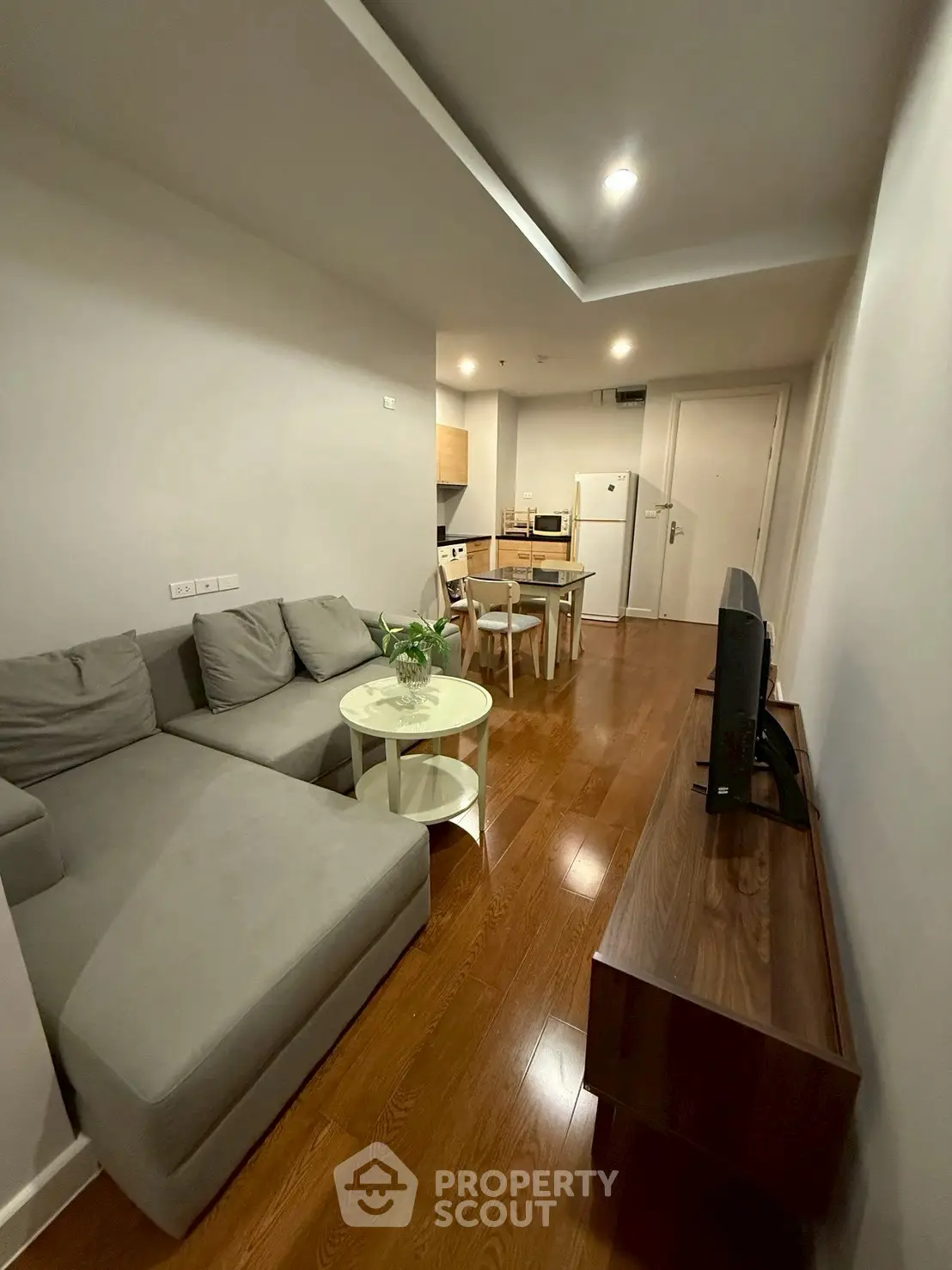 Modern living room with sleek furniture and wooden flooring in a cozy apartment.