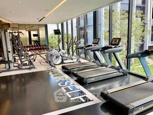 Modern gym with treadmills and weight machines in luxury building