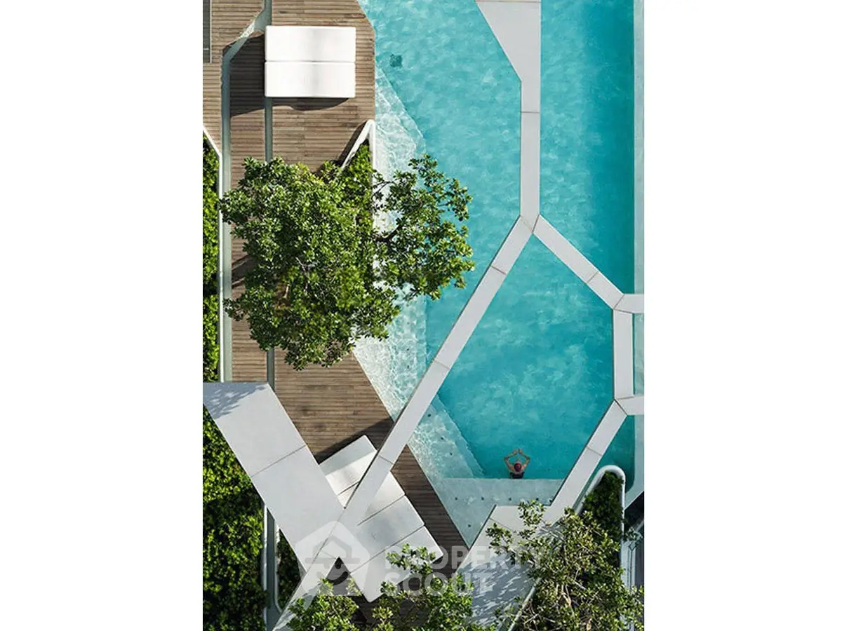 Stunning aerial view of a modern geometric swimming pool surrounded by lush greenery.