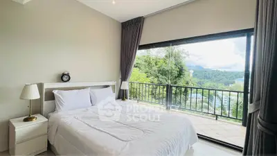 Spacious bedroom with stunning balcony view of lush greenery and mountains.