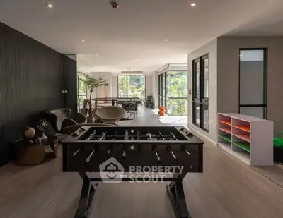 Spacious modern living area with foosball table and large windows