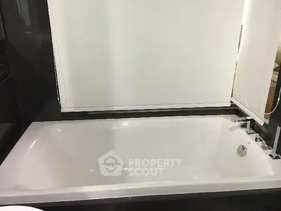Luxurious bathroom featuring a sleek modern bathtub with elegant fixtures.