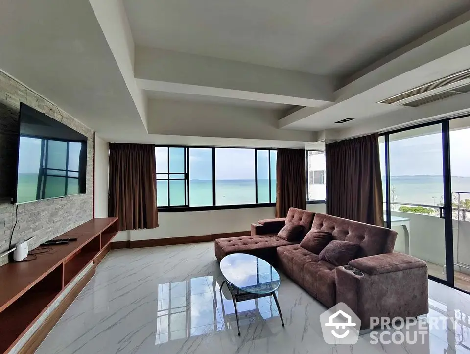 Luxurious beachfront living room with panoramic ocean views and modern furnishings.