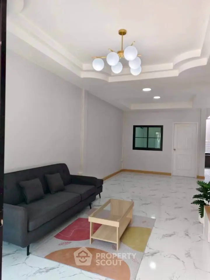 Spacious living room with modern chandelier and marble flooring