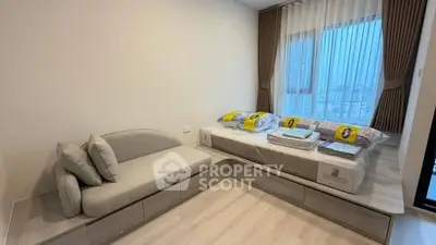 Modern bedroom with cozy sofa and stylish bed, featuring large windows and elegant curtains.
