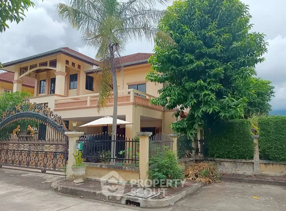 Stunning two-story villa with lush garden and elegant entrance gate