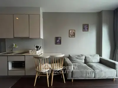 Modern living room with cozy sofa and compact kitchen area, perfect for urban living.