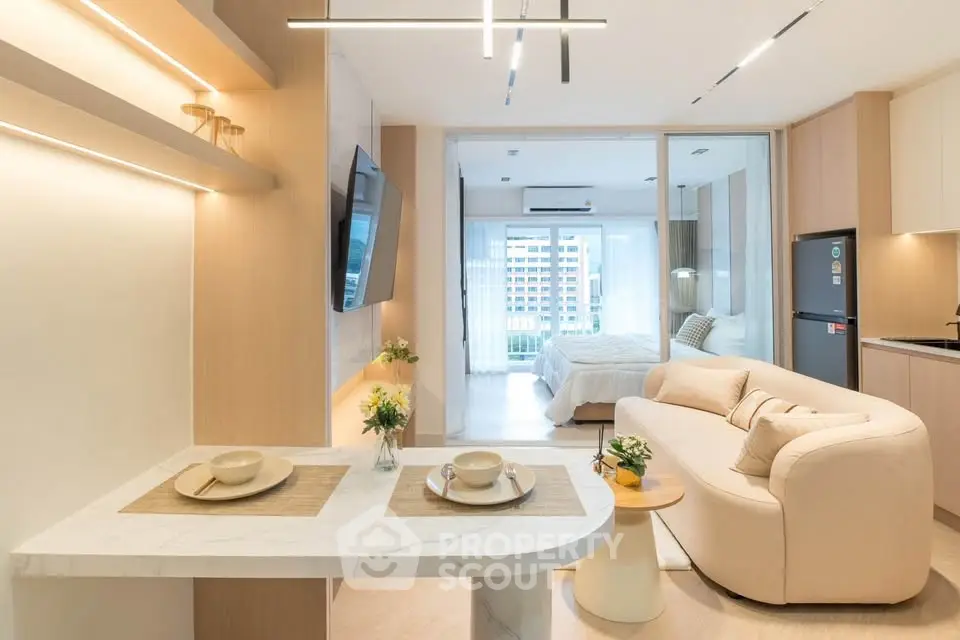 Modern open-plan living room with stylish kitchen and cozy bedroom view