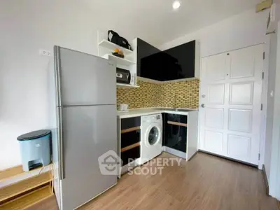 Modern kitchen with sleek appliances and stylish backsplash in a cozy apartment.