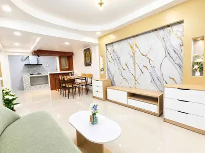 Spacious modern living room with elegant marble accent wall and open kitchen layout