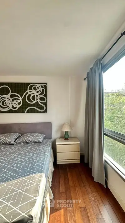 Bright bedroom with large window and modern decor in a stylish apartment.